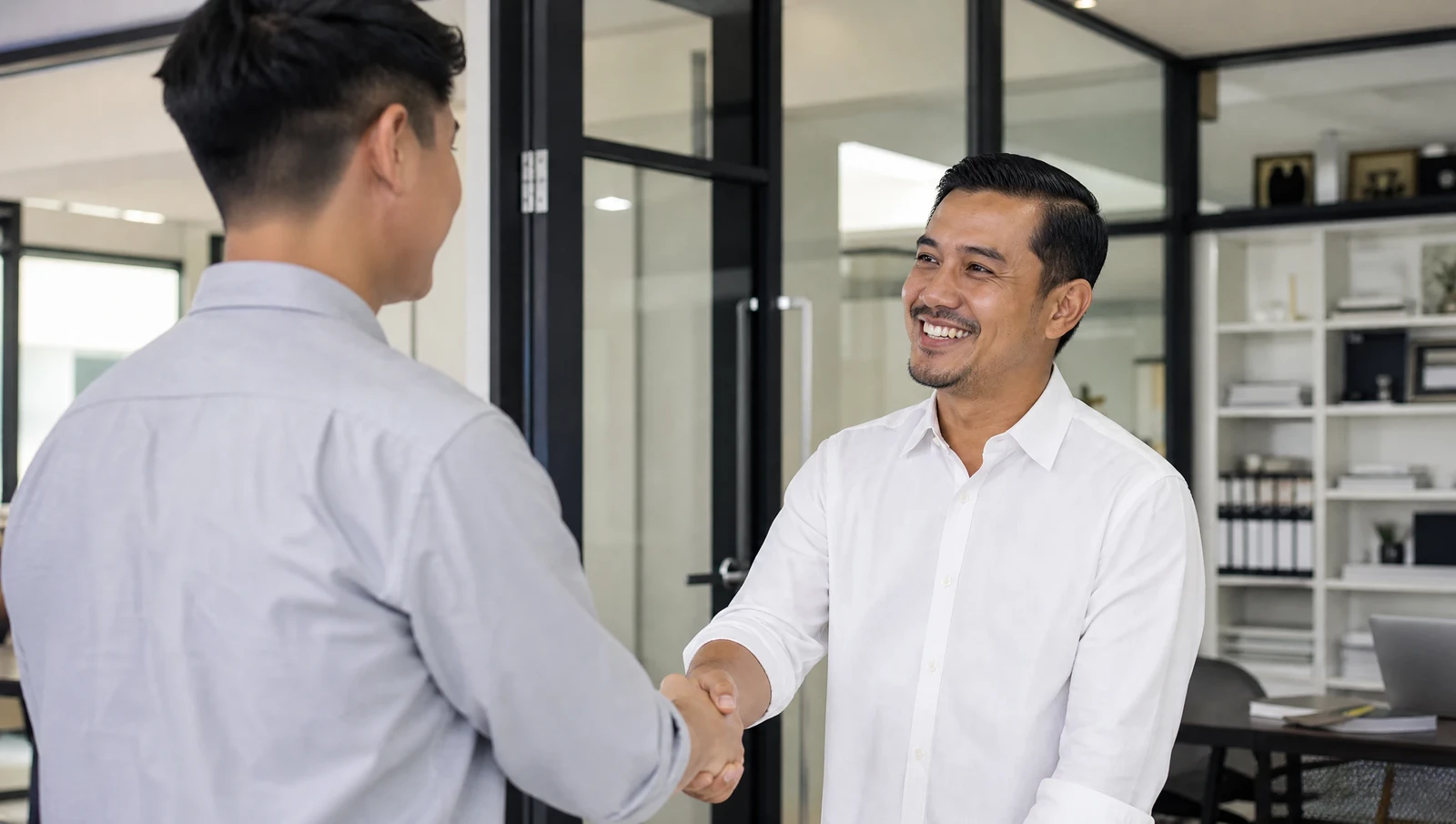 A Malaysian small business owner welcoming a new employee on their first day